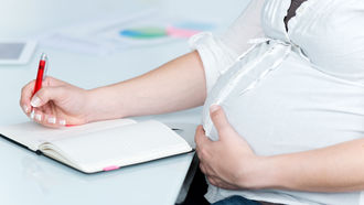 Schwangere Frau am Schreibtisch