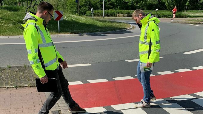 Ortstermin: Clemens Vogelsang und Andreas Koch schauen sich die rot eingefärbte Radfahrerfurt zwischen Kreisverkehr und Fußgängerübergang an