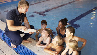 Sportlehrer und Schüler im Schwimmbad
