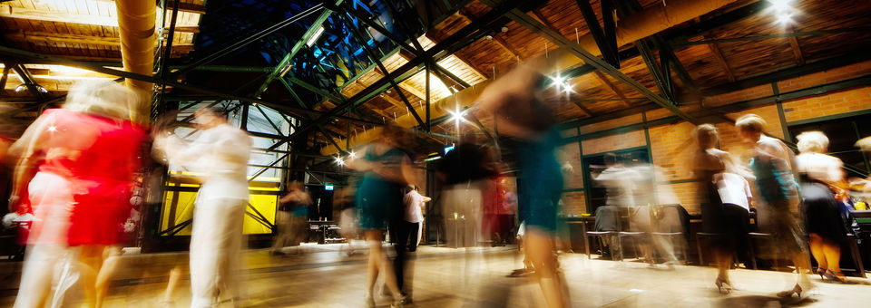 Menschen tanzen in Industriehalle