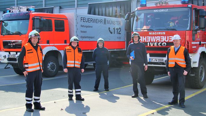 fünf Feuerwehrmänner und zwei Einsatzfahrzeuge der Feuerwehr