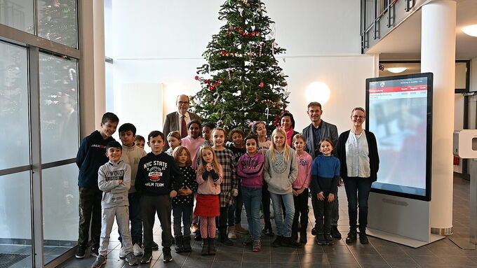 Einige Schüler:innen der Grundschule Kinderhaus-West haben den Weihnachtsbaum im Overberg-Haus der Bezirksregierung Münster geschmückt.