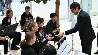 Regierungspräsident Andreas Bothe bedankt sich bei dem Blasorchester des Gymnasiums Paulinum für die musikalische Untermalung der Veranstaltung.