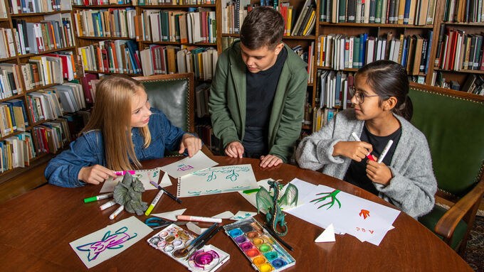 Kindergruppe malt und zeichnet in einer Bibliothek