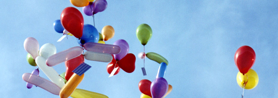 Kinderballone fliegen in Wolken
