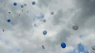 Kinderballone fliegen in Wolken