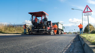 Straßenbauarbeiter asphaltieren neue Straße