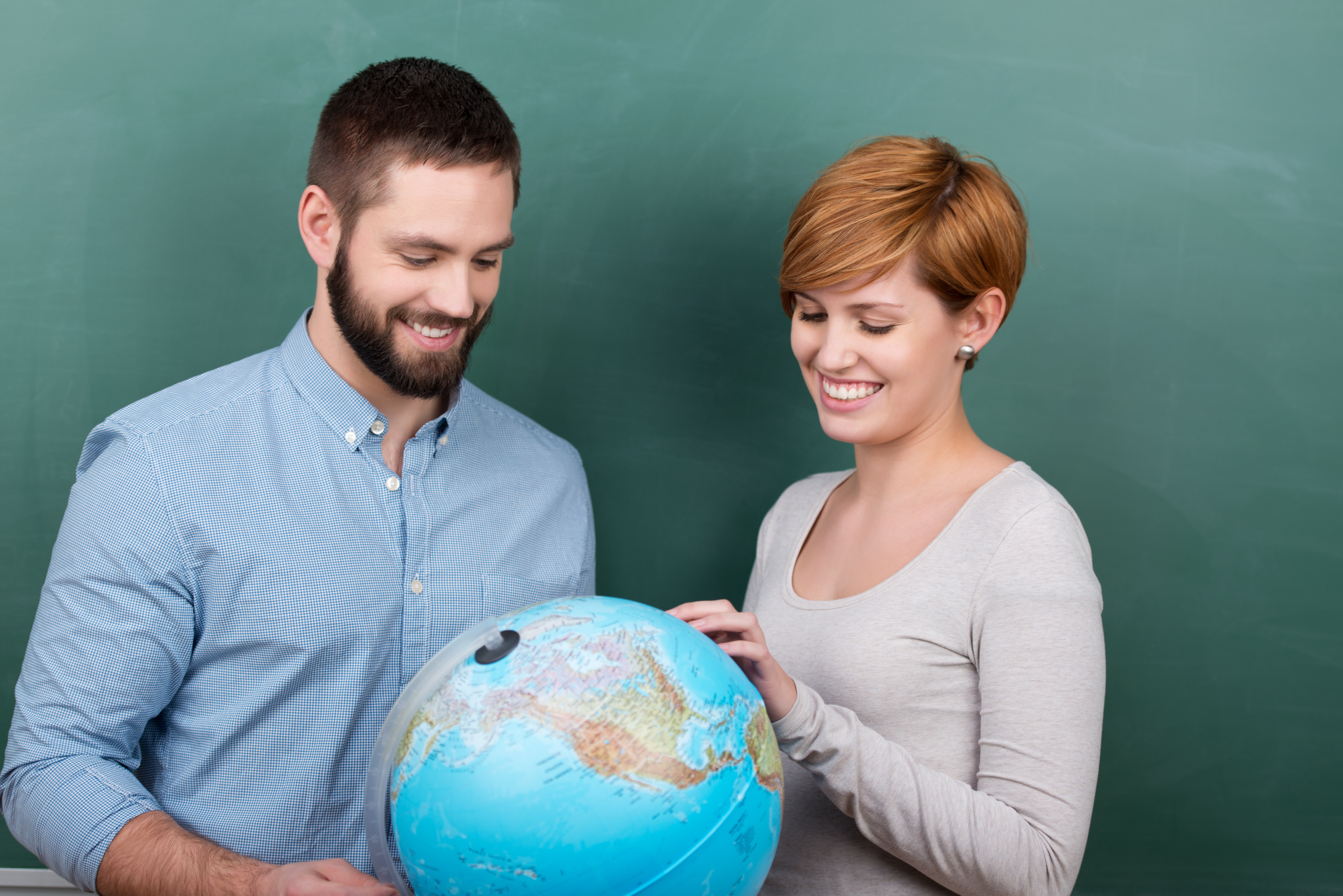 Mann und Frau schauen auf einen Globus