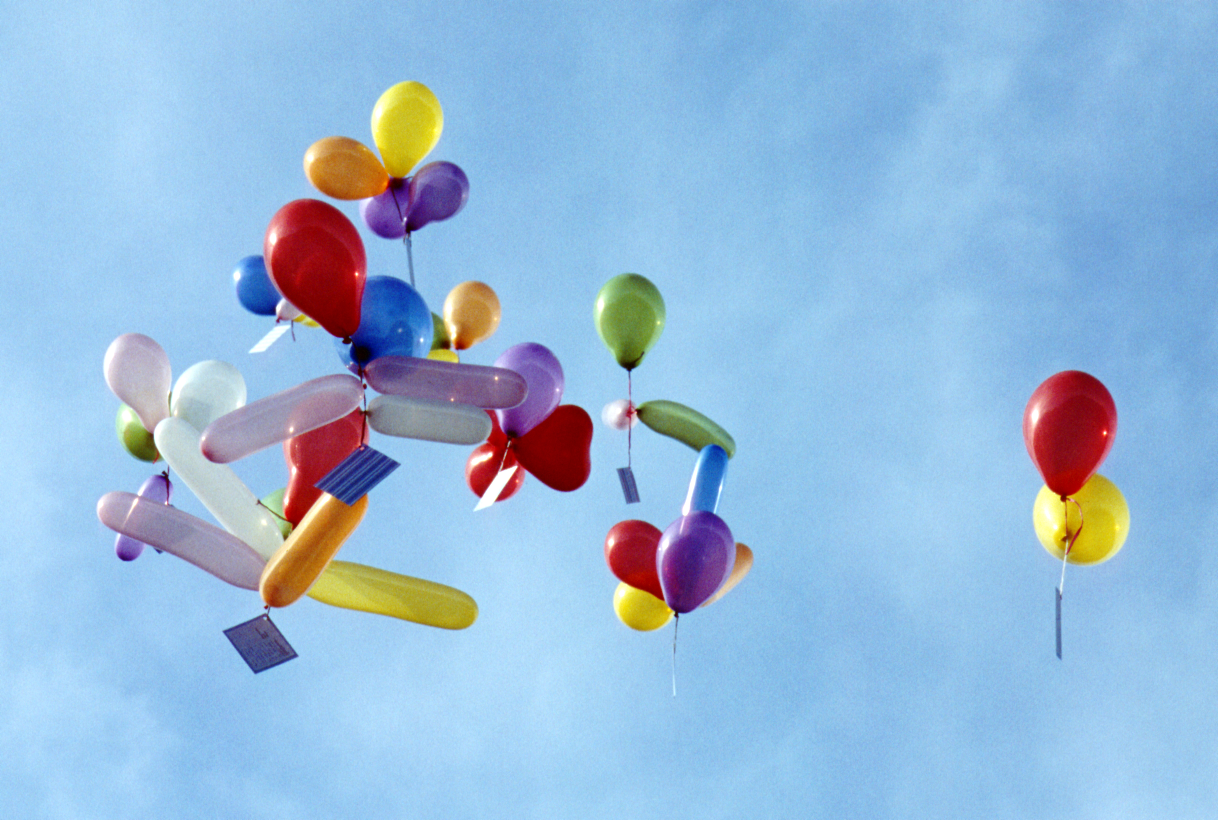 Bunte Ballons mit Postkarten steigen in den Himmel
