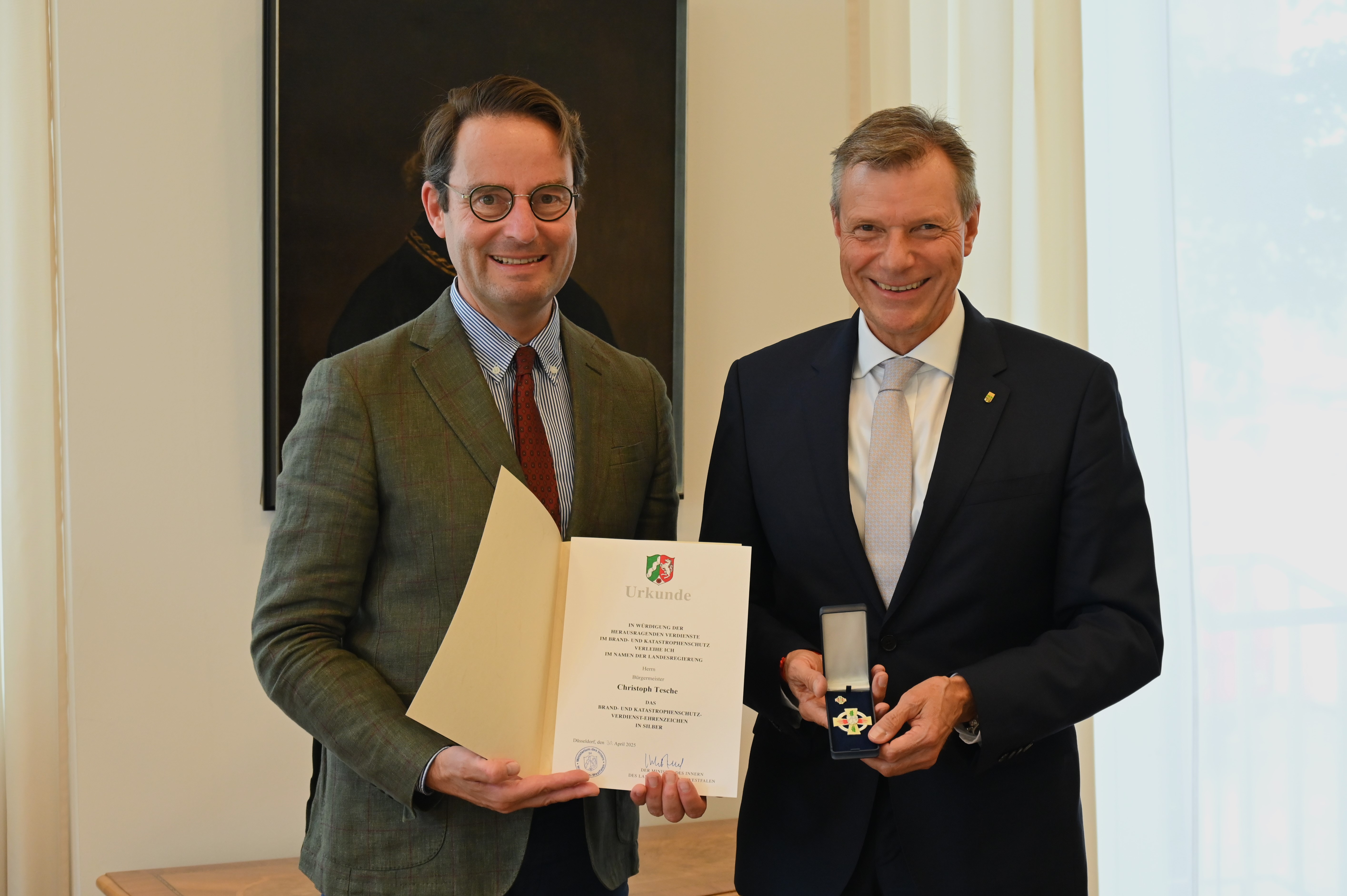 Regierungspräsident Andreas Bothe (l.) überreicht das Brand- und Katastrophenschutz-Verdienst-Ehrenzeichen an Christoph Tesche (r.).