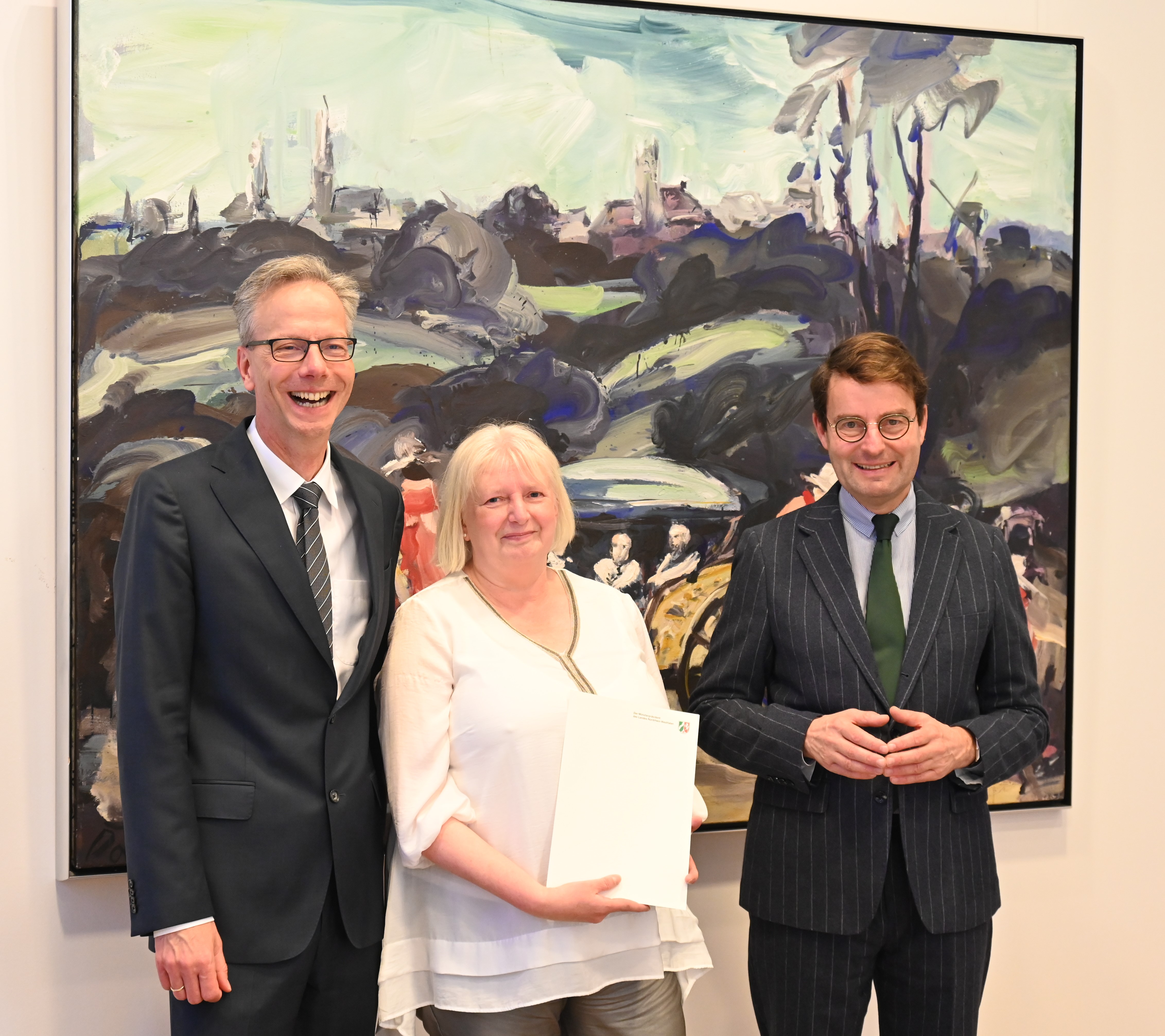 Regierungspräsident Andreas Bothe (re.) und Regierungsvizepräsident Dr. Ansgar Scheipers (li.) überreichten Ursula Lütkehermölle ihre Jubiläumsurkunde