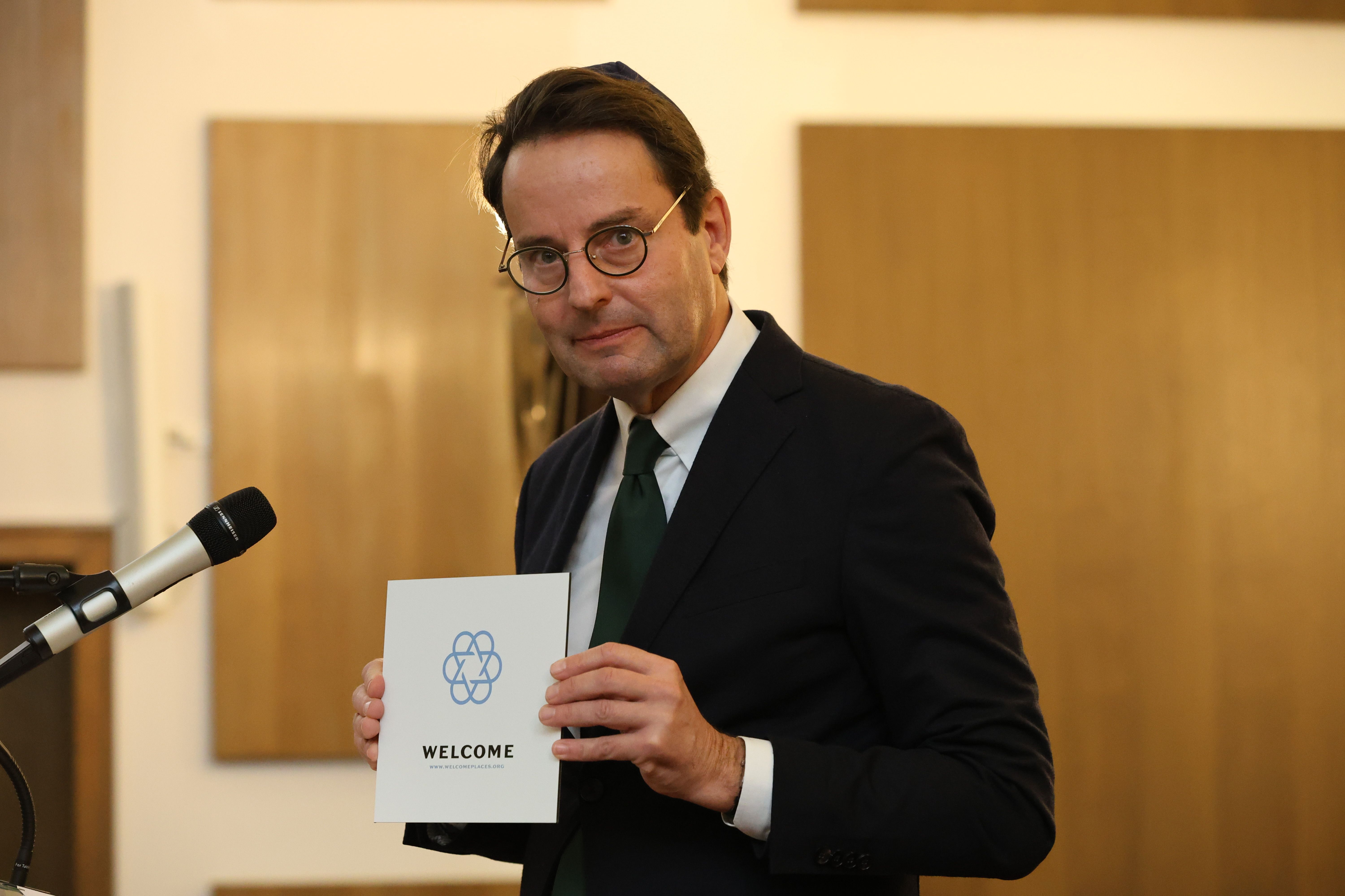 Regierungspräsident Andreas Bothe zeigte das Welcomeplace-Schild während der Gedenkveranstaltung in der Synagoge Münster. 