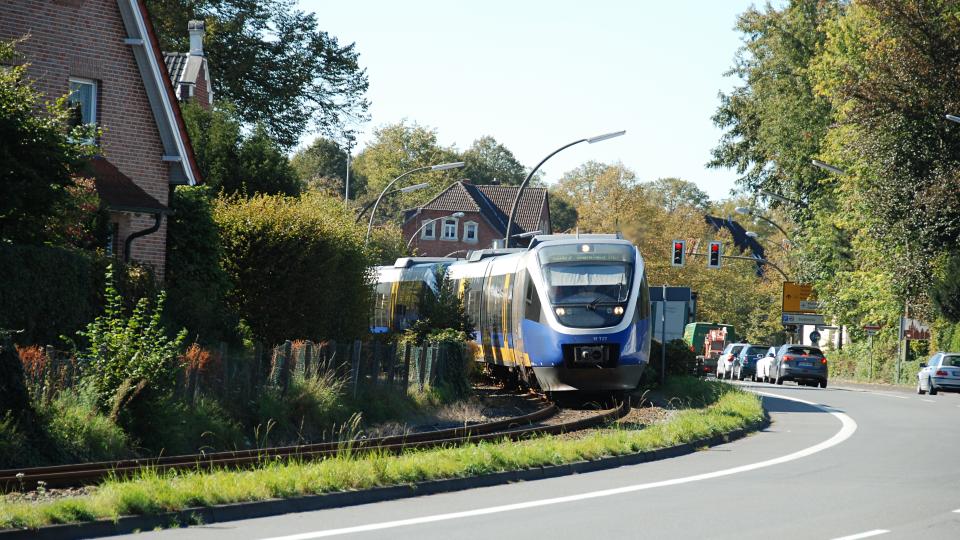 Personenzug fährt auf Schienen in Kurve