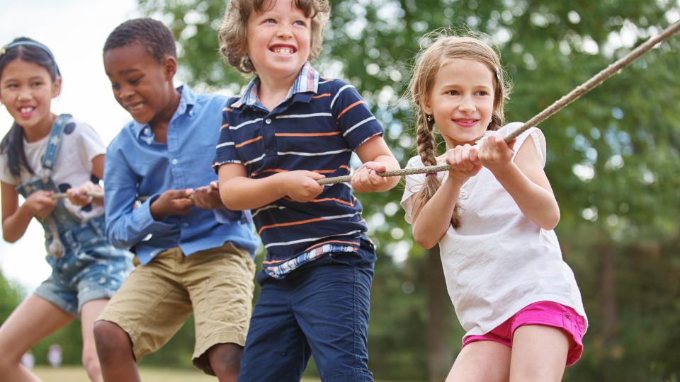 Vier Kinder spielen Tauziehen