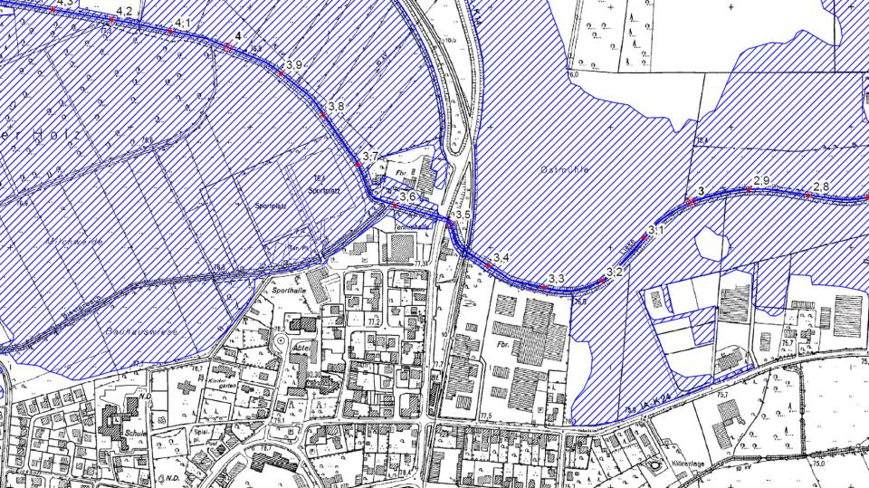 Die thematische Karte zeigt einen Ausschnitt einer Überschwemmungsgebietskarte. Im Hintergrund ist die Amtliche Basiskarte zu sehen, auf der das festgesetzte Überschwemmungsgebiet als blau schraffierte Fläche dargestellt wird.
