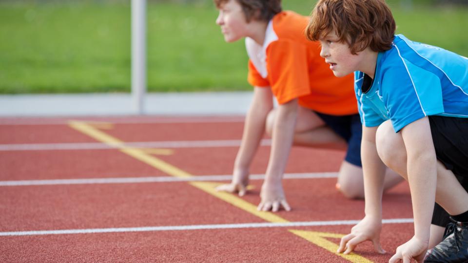 Zwei Jugendliche stehen an der Startlinie einer Rennlaufstrecke