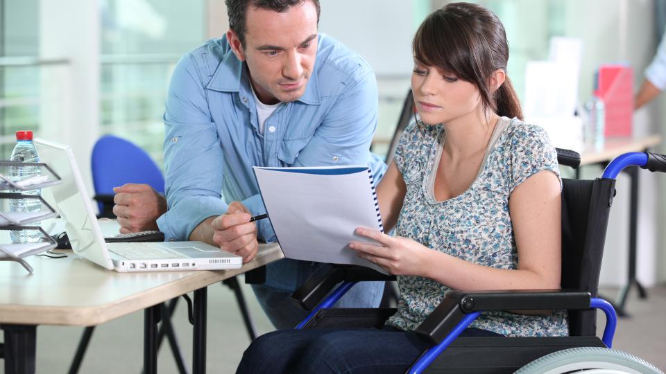 Frau im Rollstuhl im Büro