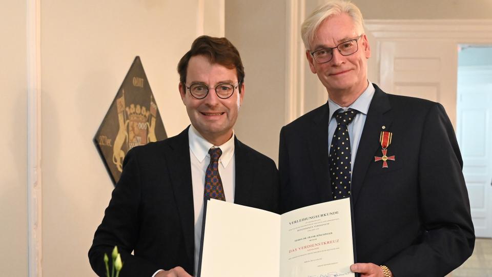  Regierungspräsident Andreas Bothe (l.) überreicht das Verdienstkreuz am Bande an Dr. Frank Röschinger (r.).