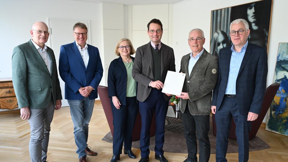 Regierungspräsident Andreas Bothe (4. v. l.) übergibt die Urkunde zur Anerkennung der „Emsdettener Stiftung für Frieden und Völkerverständigung“ an den Stiftungsvorstand.