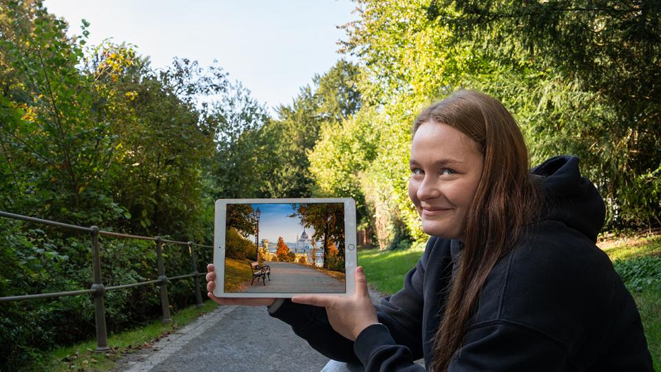 Eine Jugendliche zeigt ein Bild auf einem digitalen Endgerät