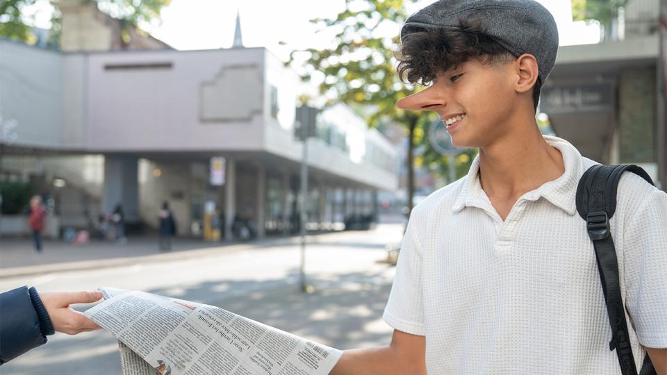 Jugendlicher verteilt eine Zeitung