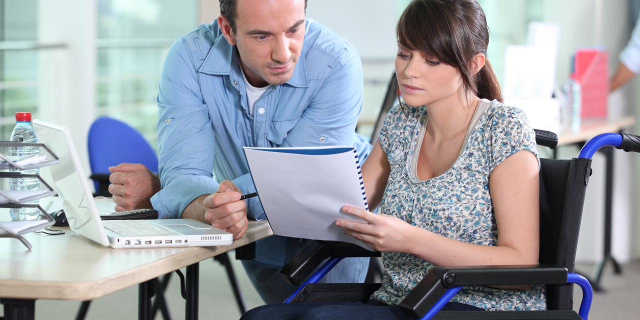 Bild von einer Rollstuhlfahrerin im Büro