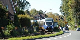 Personenzug fährt auf Schienen in Kurve