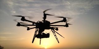 Drohne fliegt Richtung Sonnenuntergang