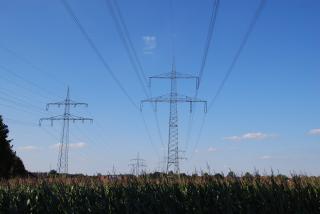 Strommasten und -leitungen über einem Feld