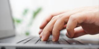 Hände tippen auf einer Laptop Tastatur