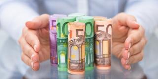 Zwei Hände stehen schützend um Bargeld