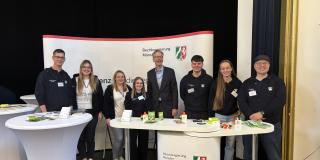 Auszubildende an einem Messestand