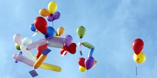 Bunte Ballons mit Postkarten steigen in den Himmel