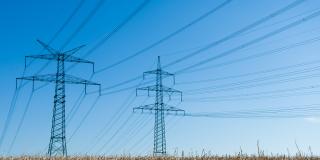 Hochspannungsleitungen über einem Feld