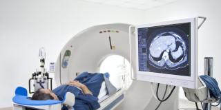 Eine Patientin wird in eine kurze Röhre für einen medizinischen Scan geschoben