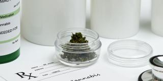 Konsumcannabis in einer Glasdose steht auf einem Zettel mit der Aufschrift Medizinisches Cannabis