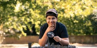 Ein Junge schaut - mit einer Lupe in der Hand - auf ein 3D-Modell von Münster 