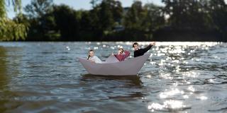 Drei Jugendliche in einem Papierboot